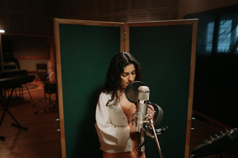 A female singer performing in a music studio with professional recording equipment.