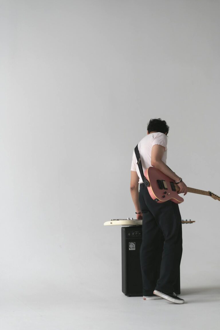 Musician playing electric guitar in a stylish minimalist studio setting, perfect for music-themed projects.