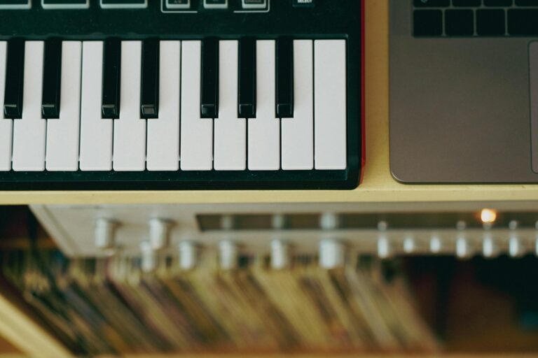 Top view of a MIDI keyboard and laptop arranged on a desk, capturing a modern music setup.